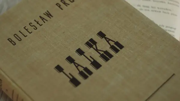 Okładka książki Bolesława Prusa "Lalka", która ukazuje motyw cierpienia w literaturze.