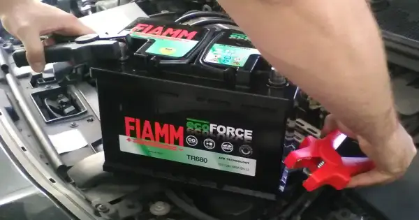 Ręce podłączają kable do akumulatora FIAMM ecoFORCE. Widoczne oznaczenia na akumulatorze, w tym model TR680 i technologia AFB.