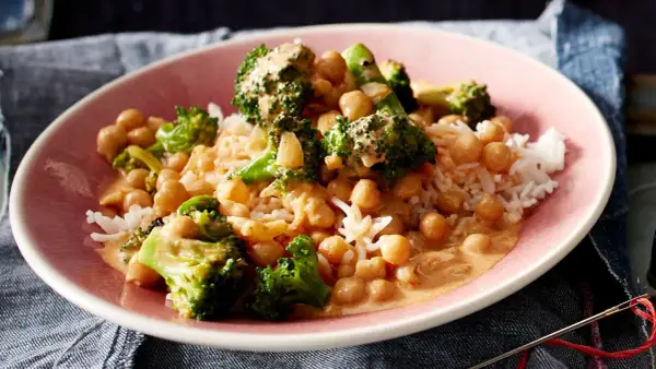 Ein Teller mit Reis, Kichererbsen und Brokkoli in cremiger Sauce. Ein leckeres Gericht, das zeigt, wie vielseitig Kichererbsen-Rezepte sein können.
