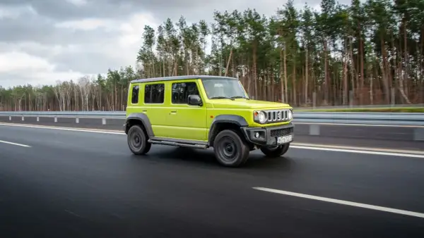 Jaskrawozielony suzuki jimny 5-drzwiowy na drodze. Sprawdź suzuki jimny 5-drzwiowy cena i możliwości.