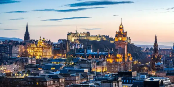 Edinburgh im Oktober: Die beleuchtete Skyline mit dem Schloss und dem Scott Monument im Abendlicht.