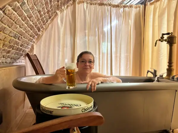 Entspannte Frau mit Bier im Bad des Chodovar Hotels.