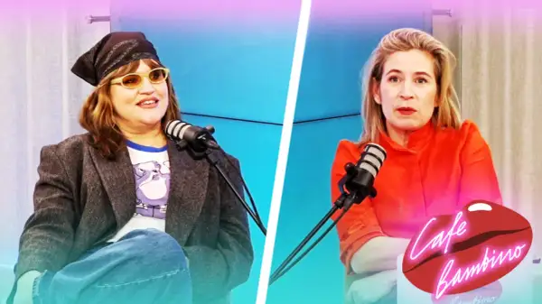 Eva Ekselius med bandana och solglasögon sitter vid en mikrofon. Bredvid henne sitter en kvinna i orange klänning.