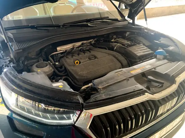 Silnik Skoda Kodiaq, widok z góry, z otwartą maską. Widać elementy silnika, reflektor i grill.