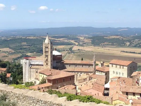 Panoramica di Massa Marittima: la cattedrale romanica con la sua torre svetta tra i tetti rossi, un invito a scoprire cosa vedere in questo borgo toscano.