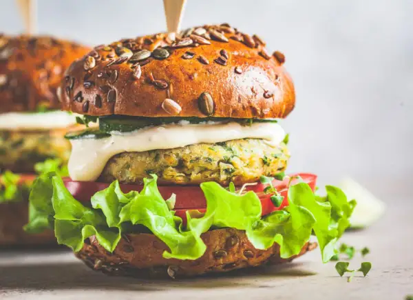 Pyszny wege burger z ziarnistą bułką, soczystą sałatą, pomidorem i kremowym sosem. Zastanawiasz się, ile kalorii ma wege burger?