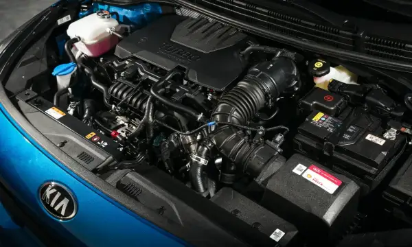 Detalle de los motores Kia, con el logo de la marca en azul brillante y componentes del motor turbo.