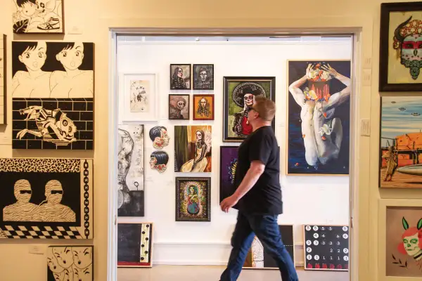 A man walks through a doorway into a vibrant display of art, showcasing diverse styles at Santa Fe art galleries.