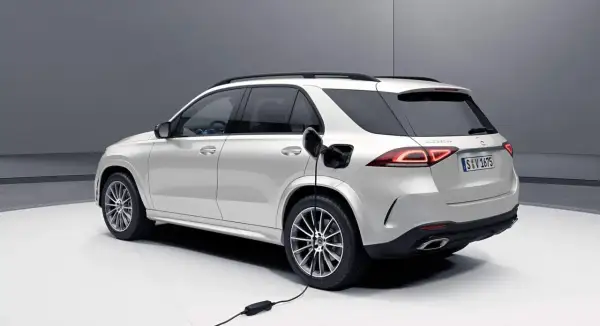 Biały SUV Mercedes-Benz jest ładowany. Zastanawiasz się, czy warto kupić hybrydę? Ten model pokazuje przyszłość motoryzacji.