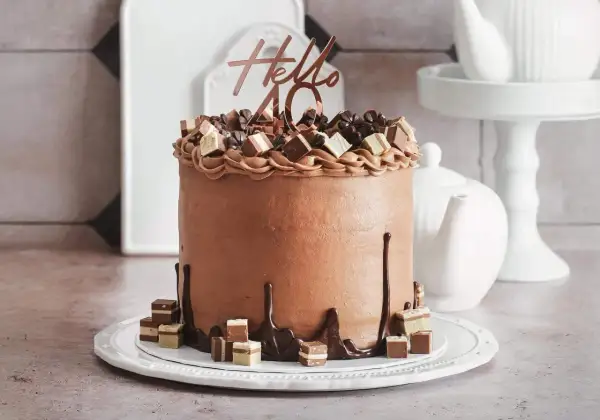 Eine üppige Schoko Torte mit "Hello 40" Topper und Schokoladenstückchen.