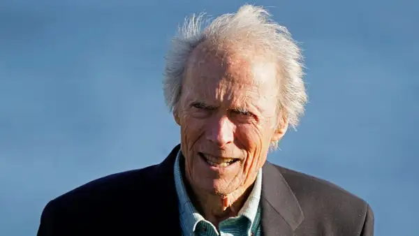 Clint Eastwood heute, mit seinem charakteristischen Lächeln und zerzaust grauem Haar, blickt in die Kamera.