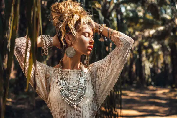 Kobieta w koronkowej sukience i bogatej biżuterii, uosobienie stylu boho. Jej stylizacje to kwintesencja wolności i natury.