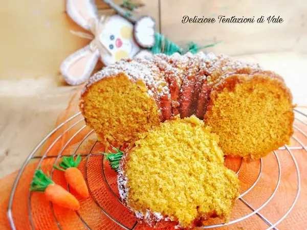 Torta di carote Bimby soffice e profumata, decorata con zucchero a velo e carotine decorative.