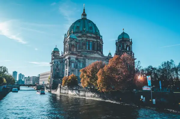 Berliński Dom na tle błękitnego nieba, z łodzią na rzece. Piękne miasta w Niemczech jesienią.
