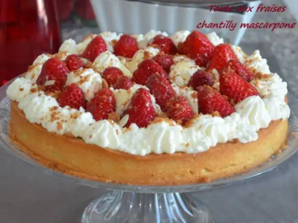 Délicieuse tarte aux fraises chantilly, garnie de fruits rouges frais et de crème onctueuse, saupoudrée de miettes croustillantes.
