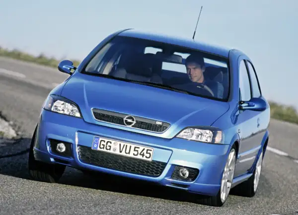 Niebieski Opel Astra G CC z kierowcą na drodze.