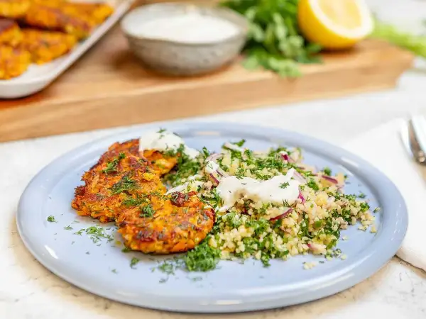 Halloumi och morotsbiffar serveras med en fräsch bulgursallad och en klick yoghurt. En härlig vegetarisk rätt!