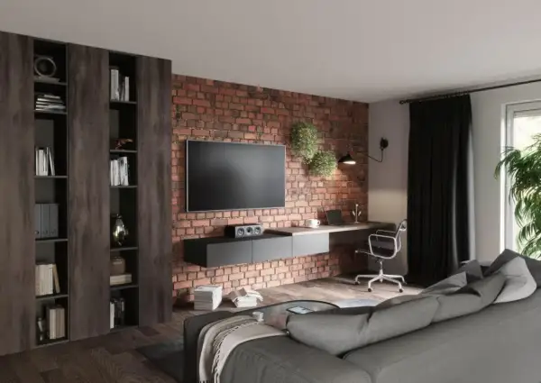 Nowocześnie urządzony salon z ceglaną ścianą, wiszącym TV, biurkiem i wygodną kanapą. Inspiracja, jak urządzić salon nowocześnie.