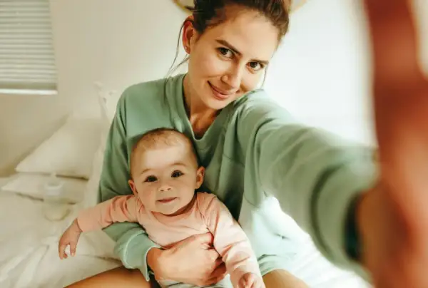 Uśmiechnięta mama z dzieckiem na rękach, czuje, kiedy macierzyństwo zaczyna cieszyć.