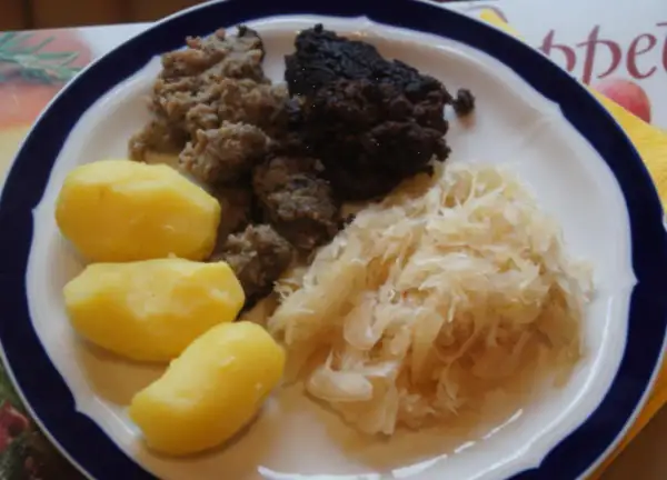 Herzhaftes Gericht: Bratwurst, Blutwurst, Sauerkraut und Salzkartoffeln. Perfekt, um Wellwurst zuzubereiten und zu genießen.