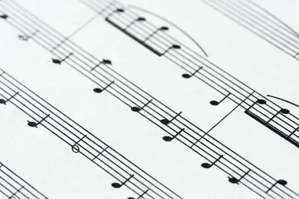 Zbliżenie na pięciolinię z nutami. Położenie nut na pięciolinii jest kluczowe do odczytania melodii.