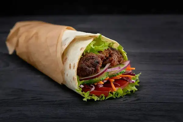 Pyszny kebab z kurczakiem, pełen świeżych warzyw i soczystego mięsa. Idealny na szybki posiłek, z myślą o kaloriach.
