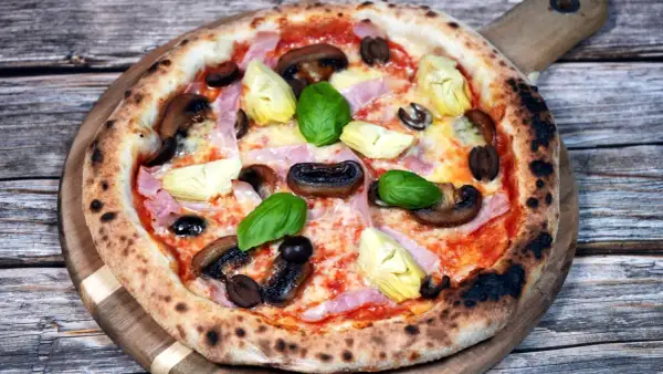 En läcker pizza capricciosa med champinjoner, kronärtskocka, skinka och oliver. Perfekt för ett mysigt kvällsmål, detta recept är en favorit.
