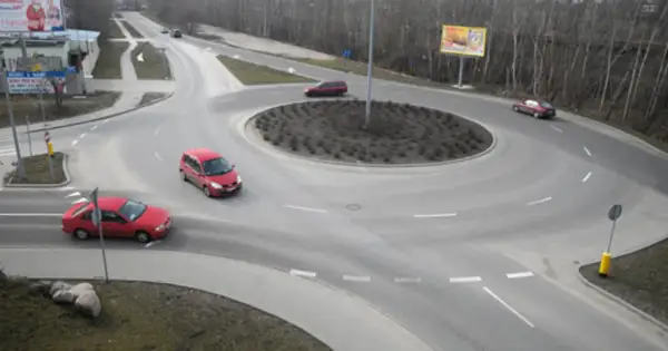 Rondo turbinowe jak jeździć: czerwone samochody płynnie poruszają się po rondzie, pokazując zasady ruchu.
