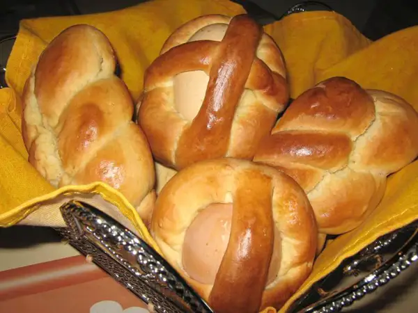 Cuzzupe calabresi morbide, dolci pasquali con uova, in un cestino foderato di giallo.