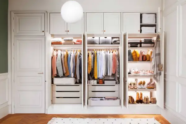 Un armario organizado es un sueño. Este proyecto armario muestra ropa colgada, cajones y estantes con bolsos y zapatos.
