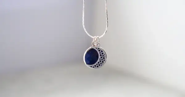 Srebrny naszyjnik z zawieszką w kształcie półksiężyca z lapis lazuli i gwiazdkami.