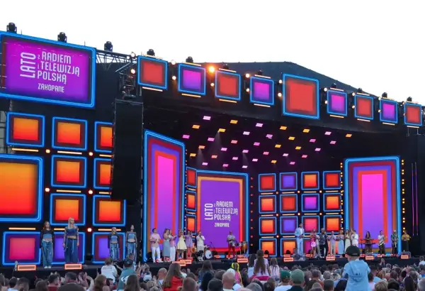 Koncert "Lato z Radiem i Telewizją Polska" w Zakopanem. Kolorowa scena z neonami i ekranami LED, artyści na scenie i tłum widzów.