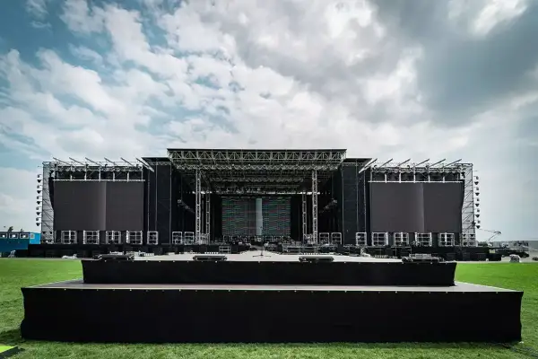Ogromna scena koncertowa RCF Arena czeka na tłumy. Metalowa konstrukcja, ekrany LED i zielona murawa pod błękitnym niebem.