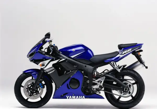 Niebieski motocykl sportowy Yamaha R6 2003 z białymi akcentami, gotowy do jazdy po torze.