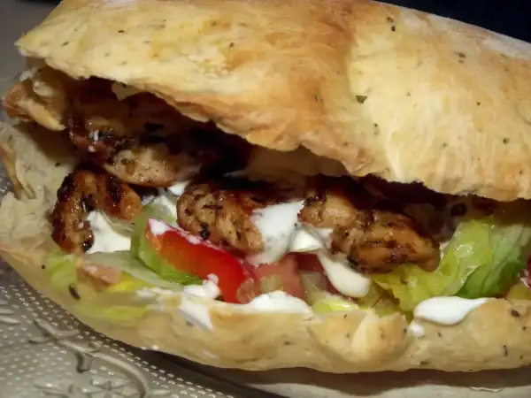 Pyszny kebab w picie z soczystym kurczakiem, świeżą sałatą, pomidorem i kremowym sosem. Idealny na szybki posiłek.