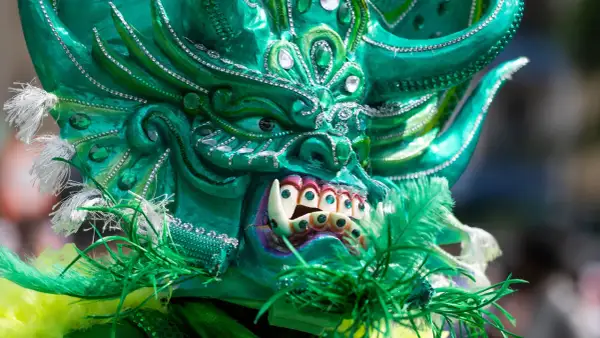 Grüne Maske mit funkelnden Steinen und Federn, ein Blickfang beim Carnival of Cultures Berlin.