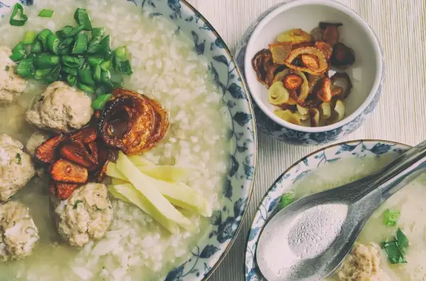 Pyszny congee z klopsikami, szczypiorkiem i chrupiącą cebulką. Idealne na rozgrzewający posiłek.