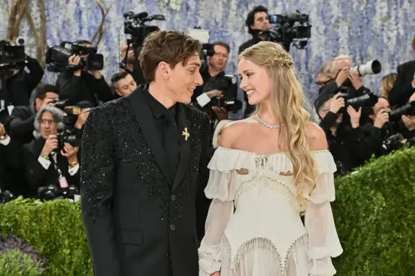 Desiré Inglander och hennes partner ler mot varandra omgivna av fotografer.