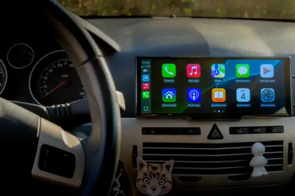 CarPlay co to? Ekran w samochodzie z ikonami: Telefon, Muzyka, Mapy, Wiadomości, Podcasty, Audiobooki, Kalendarz, Ustawienia.