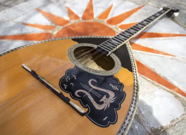 Piękny grecki instrument muzyczny, bouzouki, leży na mozaice w kształcie słońca.