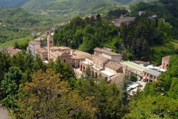 Borgo collinare con edifici in pietra e tetti in tegole, circondato da boschi rigogliosi. Un luogo incantevole da amandola cosa vedere.