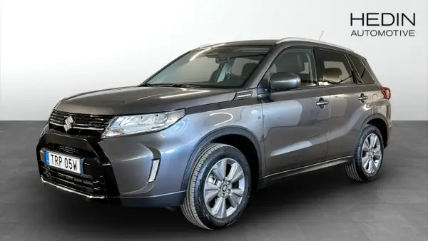 En mörkgrå Suzuki Vitara Hybrid står redo för en provkörning. Denna bil är perfekt för dig som söker en pålitlig och bränslesnål SUV.