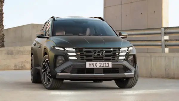 Hyundai Tucson hybrid test. En mörkgrön SUV med distinkta LED-lampor och en modern grill.