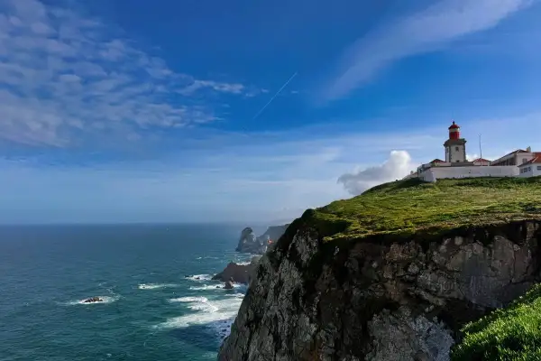 Majestatyczny **Cabo da Roca** z latarnią morską na szczycie klifu, gdzie ocean spotyka ląd.