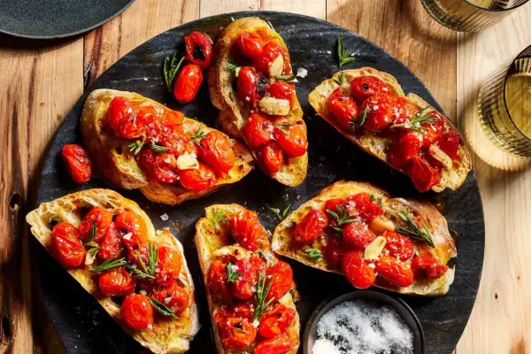 Pyszne bruschetty z pomidorkami koktajlowymi i czosnkiem. Idealne antipasti co to, by zacząć ucztę.