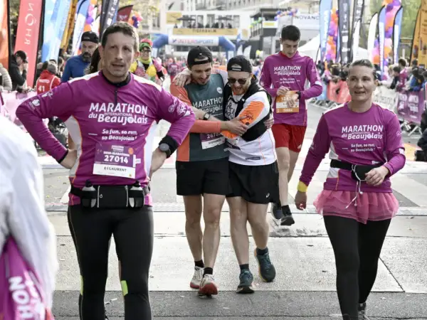 Des coureurs franchissent la ligne d'arrivée du marathon du Beaujolais. Le dénivelé a été un défi, mais l'ambiance est à la fête.