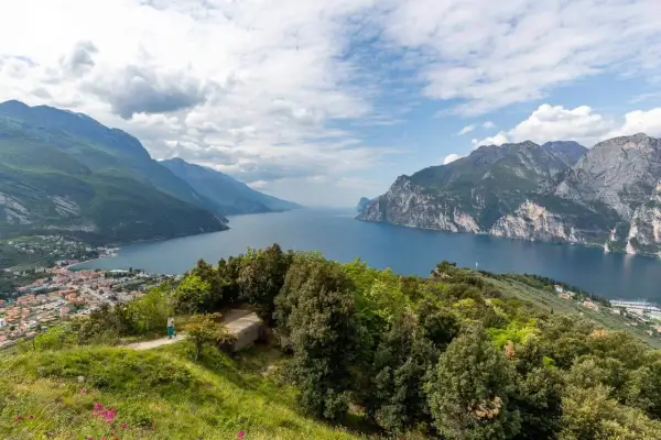 Panoramica mozzafiato del Lago di Garda, ideale per **leichte wanderungen am Gardasee**. Montagne verdi e rocciose incorniciano il blu intenso dell'acqua.