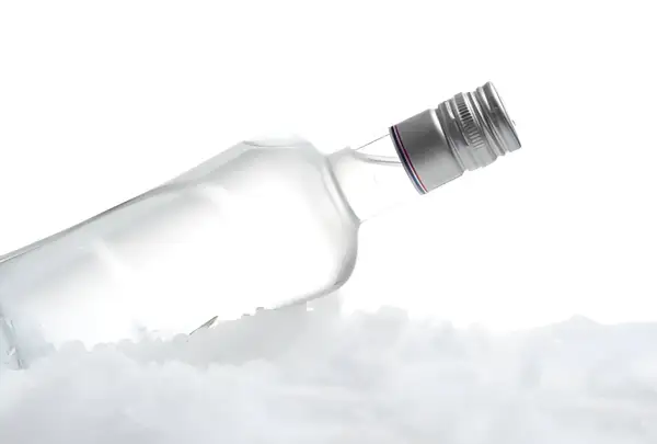 Szklana butelka wódki leży na lodzie, tworząc wrażenie, kiedy wódka zamarza.