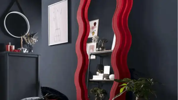 Ozdobne lustro z falowaną, czerwoną ramą. Dowiedz się, jak powiesić lustro z ramą, by stworzyć stylowe wnętrze.