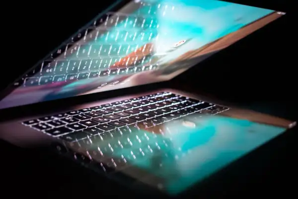 Podświetlana klawiatura laptopa odbija się w ekranie, tworząc efekt 287 kk.